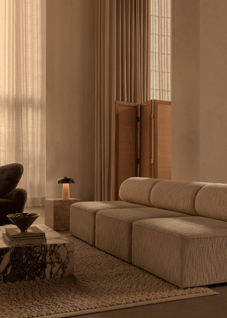 Neutral-toned modular boucle sofa with rounded back cushions, marble coffee tabl