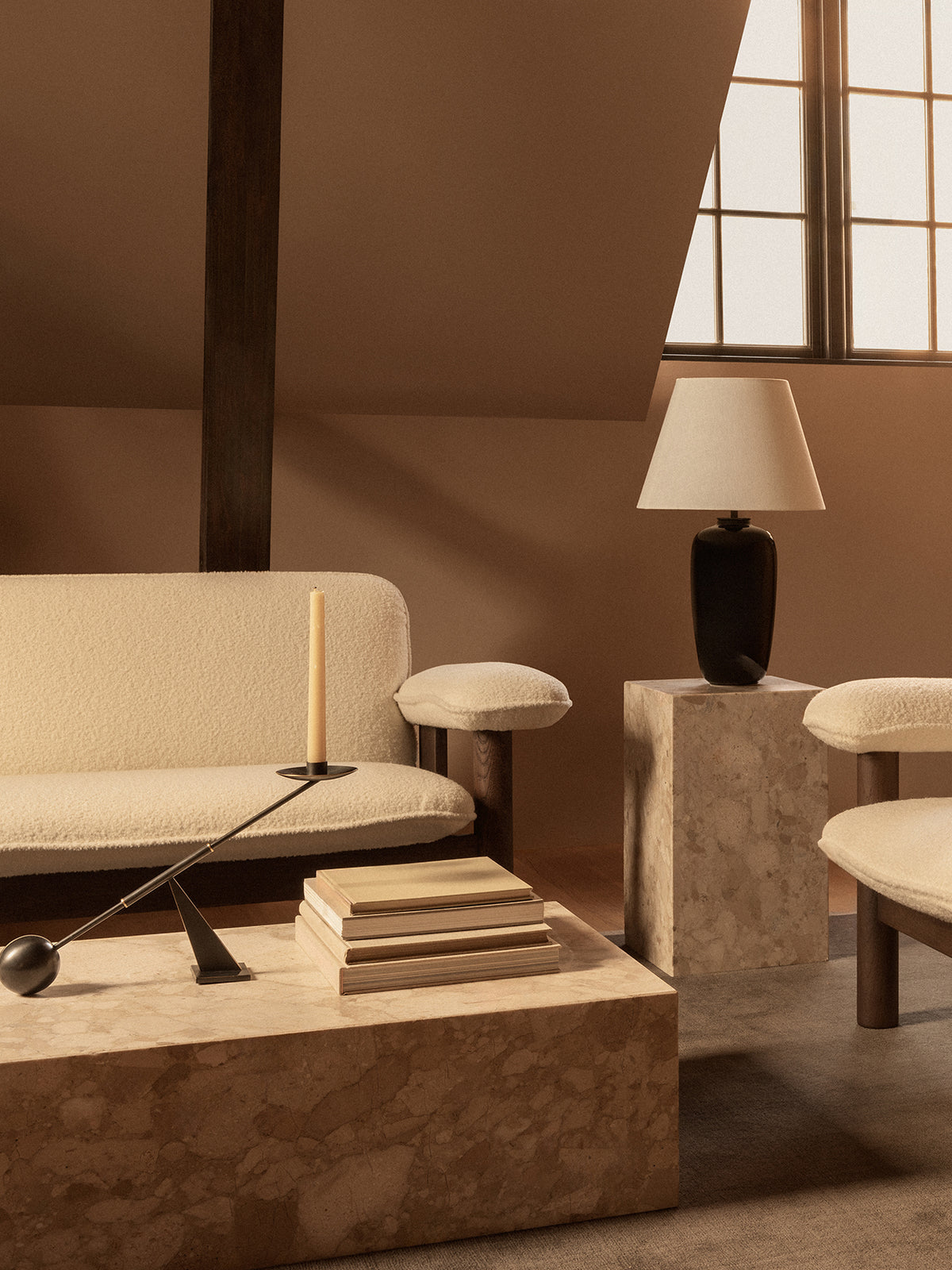 Minimal living room with cream boucle sofa and stools, beige marble low