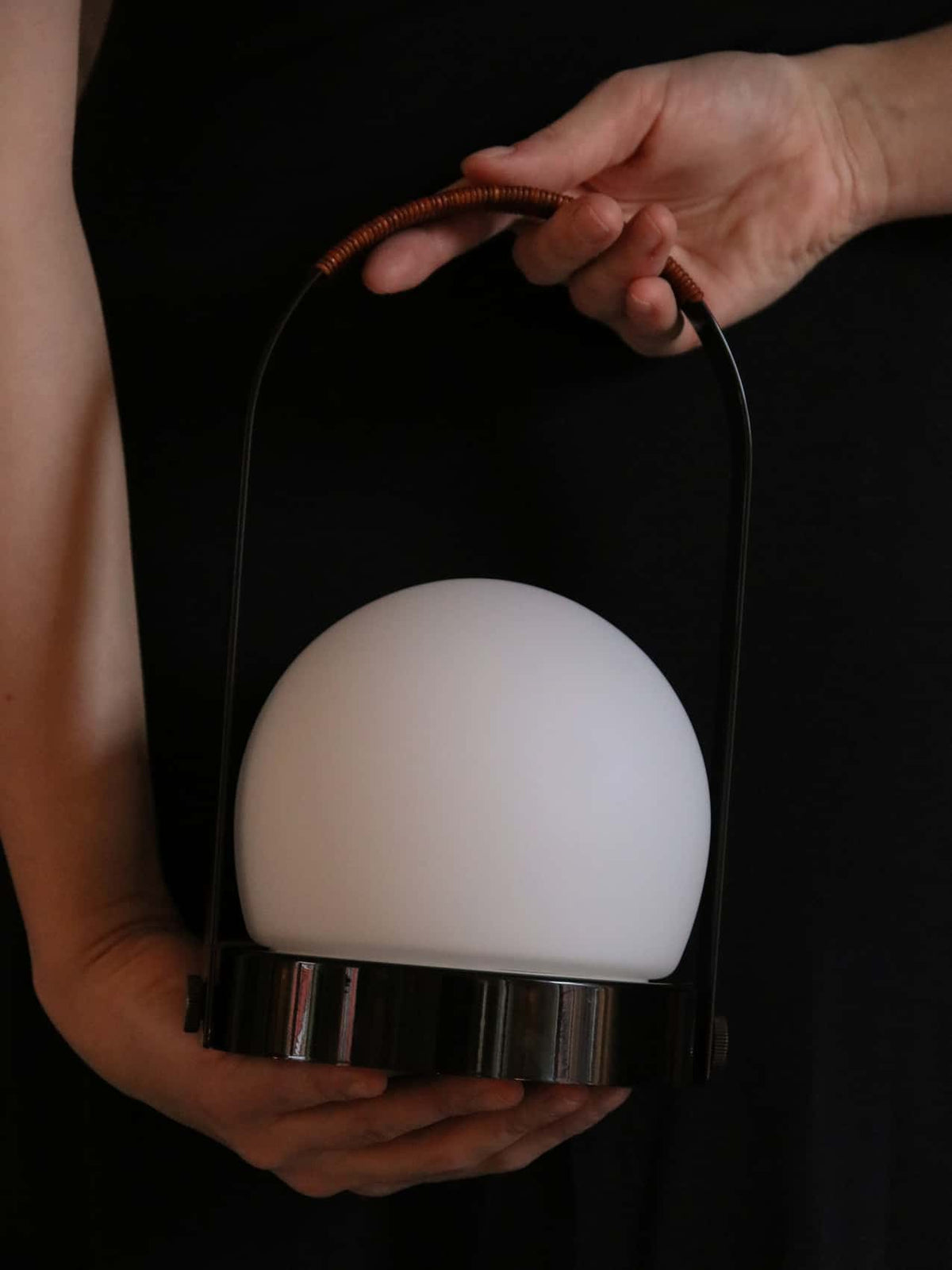 Handheld portable lamp with white frosted dome, chrome base and black metal