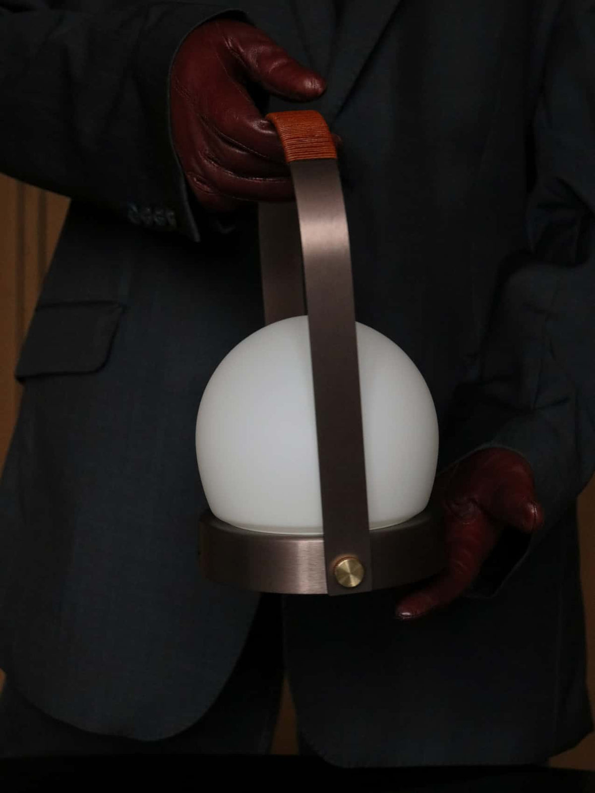 Handheld table lamp with white opal glass globe, bronze metal frame and