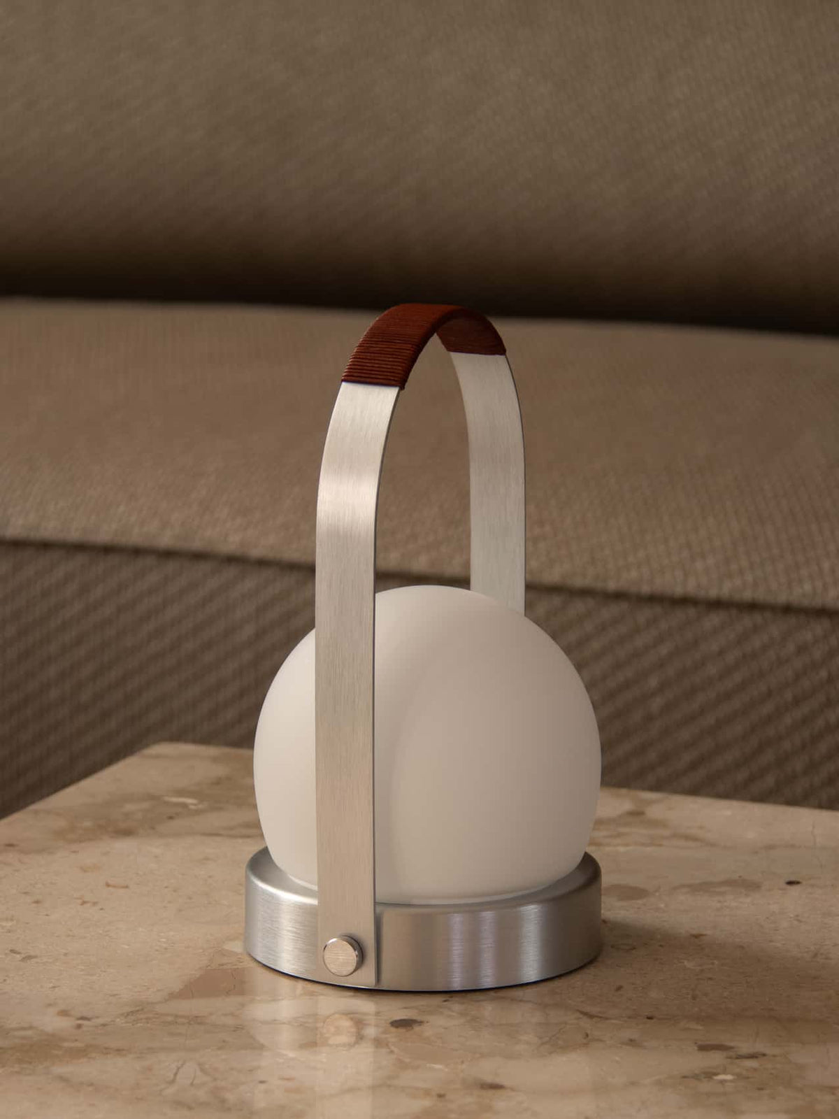 Brushed steel portable lamp with frosted white globe, arched handle with brown