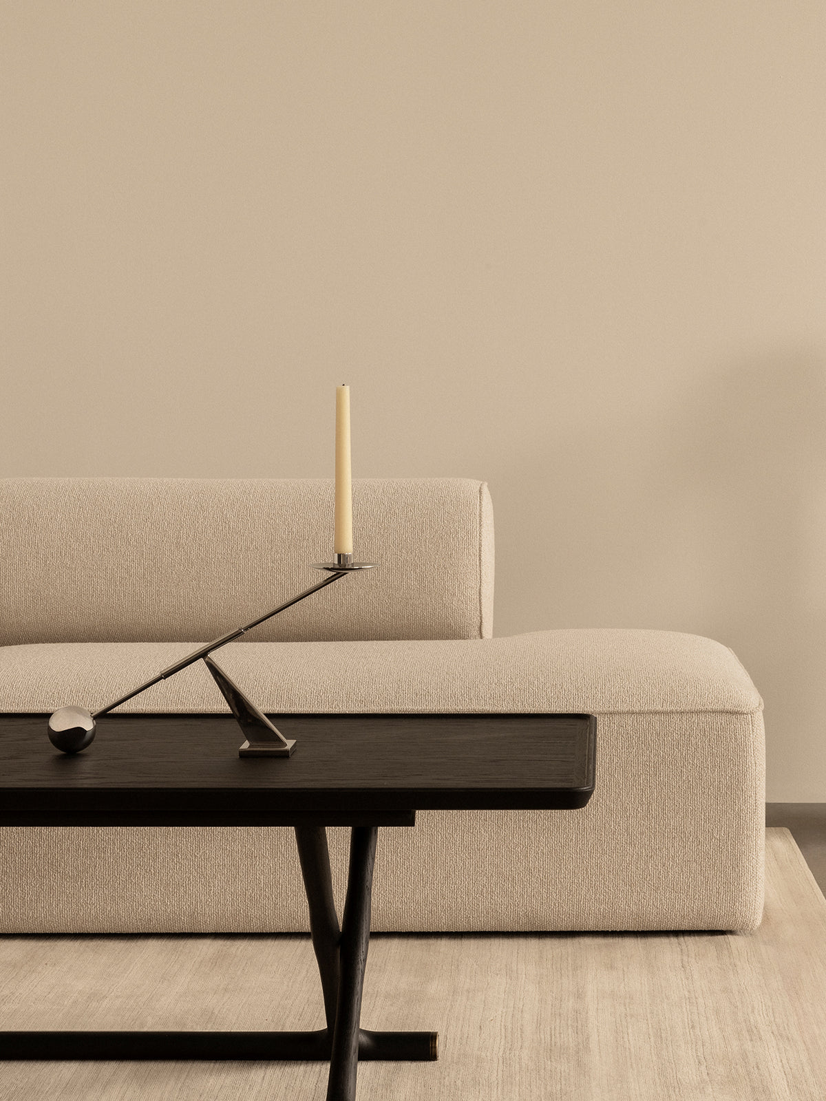 Schwarzer Jäger Lounge Table mit Interconnect Kerzenhalter vor einem beigen Eave