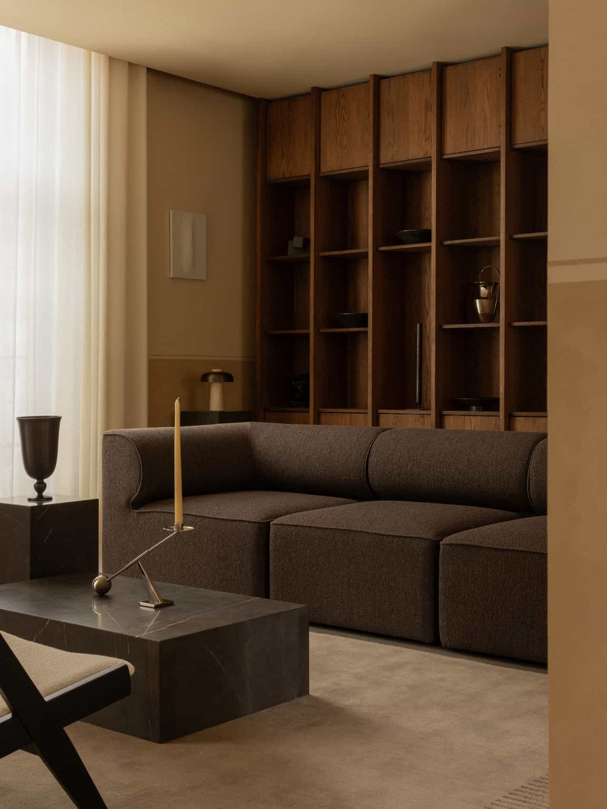 Warm living room with dark brown modular fabric sofa, black marble coffee