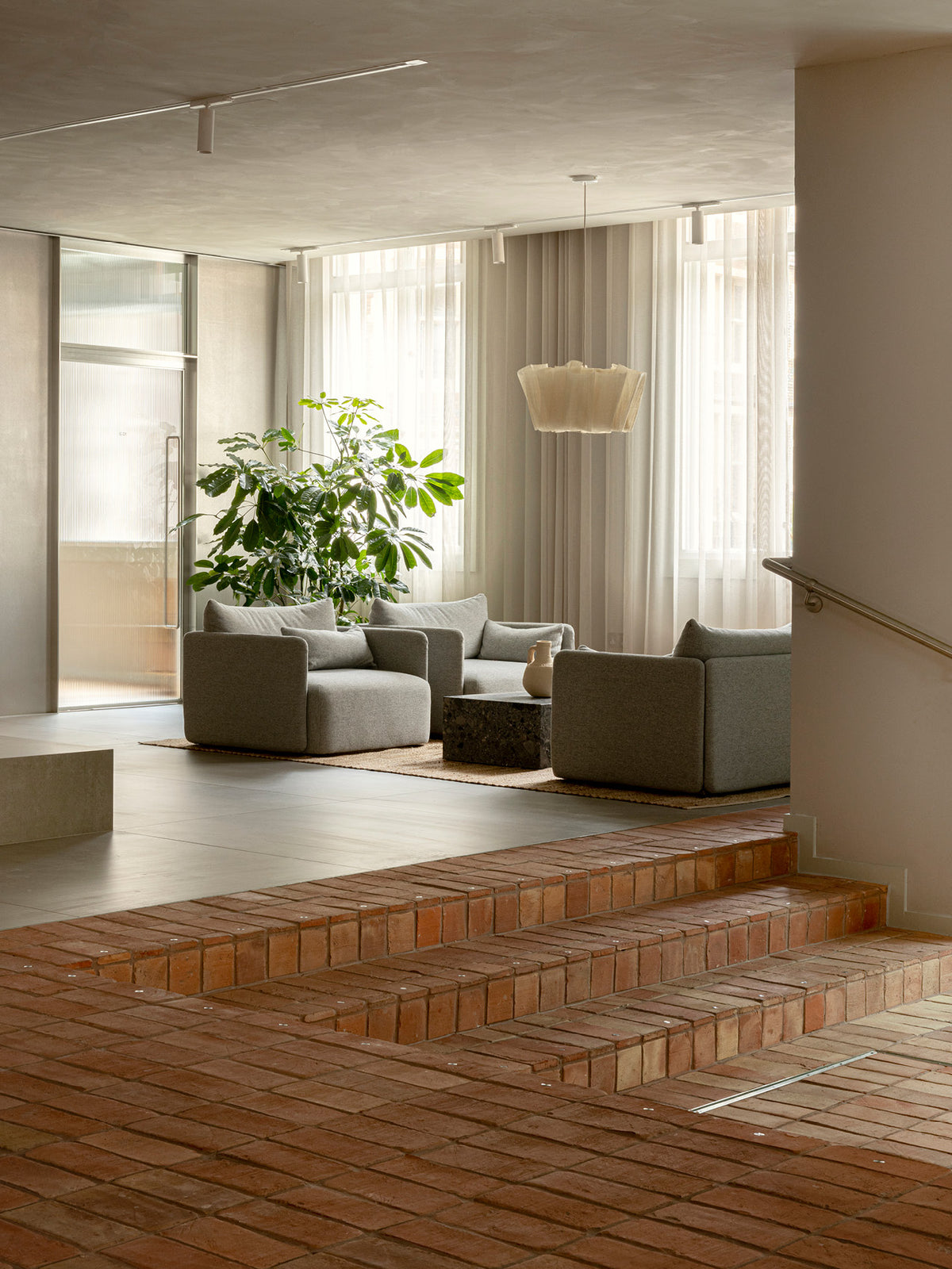 Minimal living room with gray modular sofas around a low marble coffee