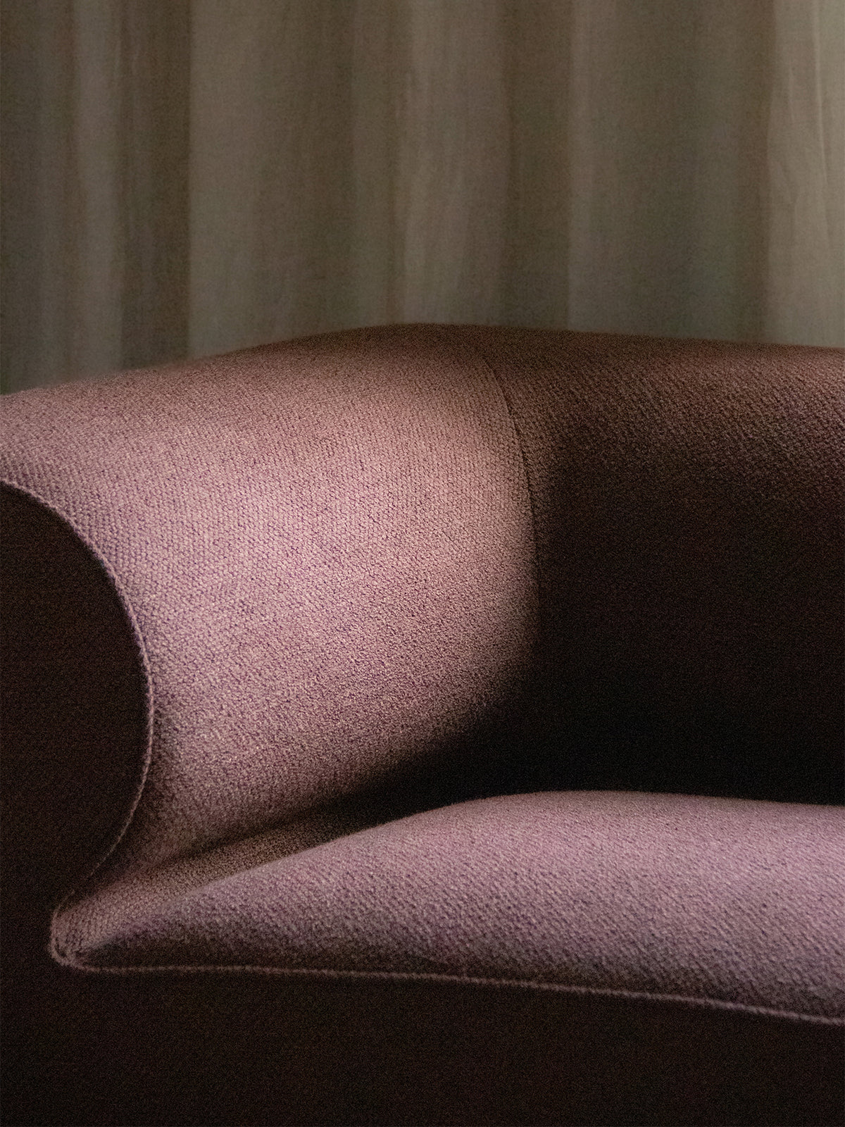 Nahaufnahme der geschwungenen Armlehne des Eave Modular Sofas aus strukturiertem