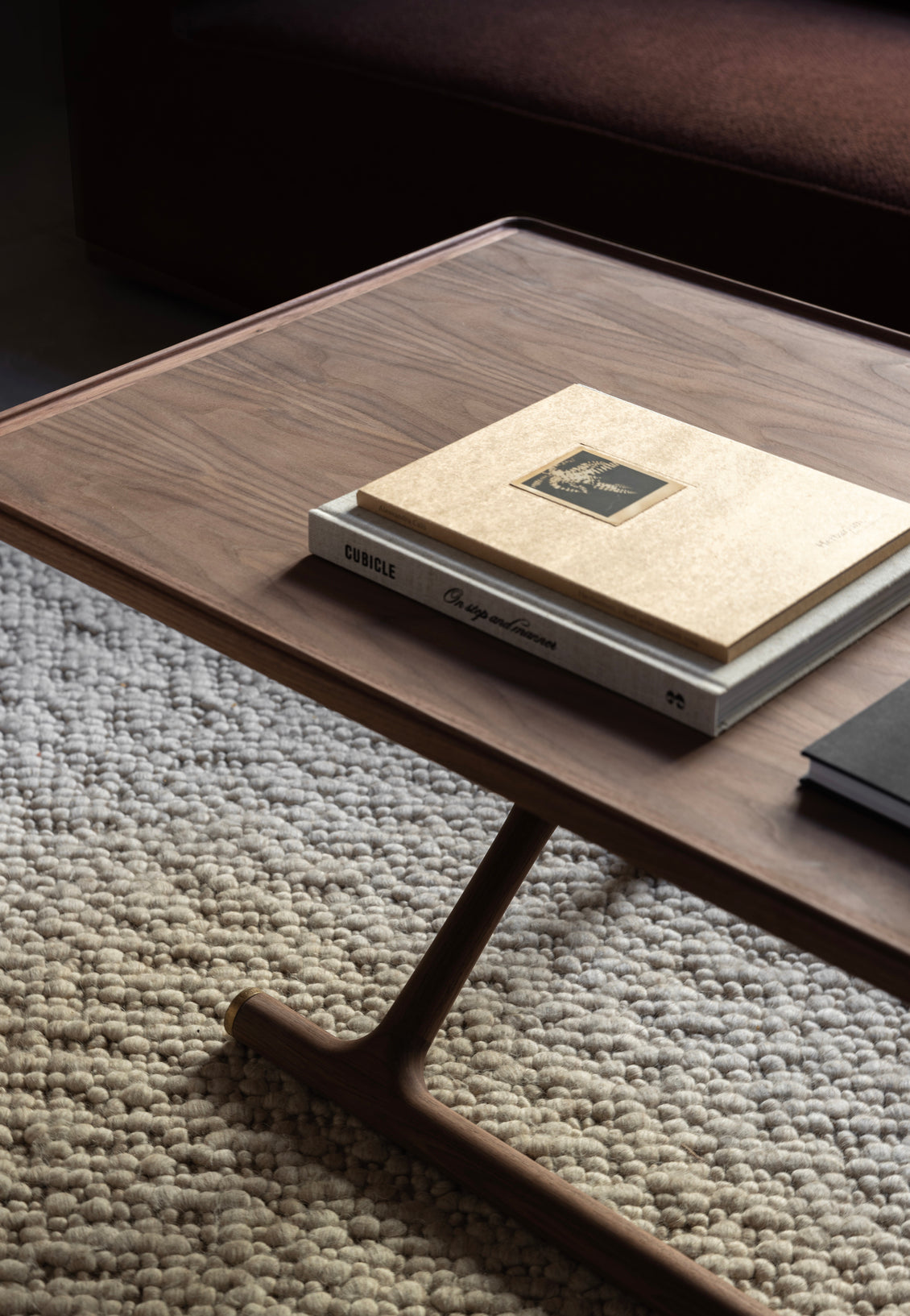 Walnut rectangular coffee table with rounded tray edge, stacked beige and gray