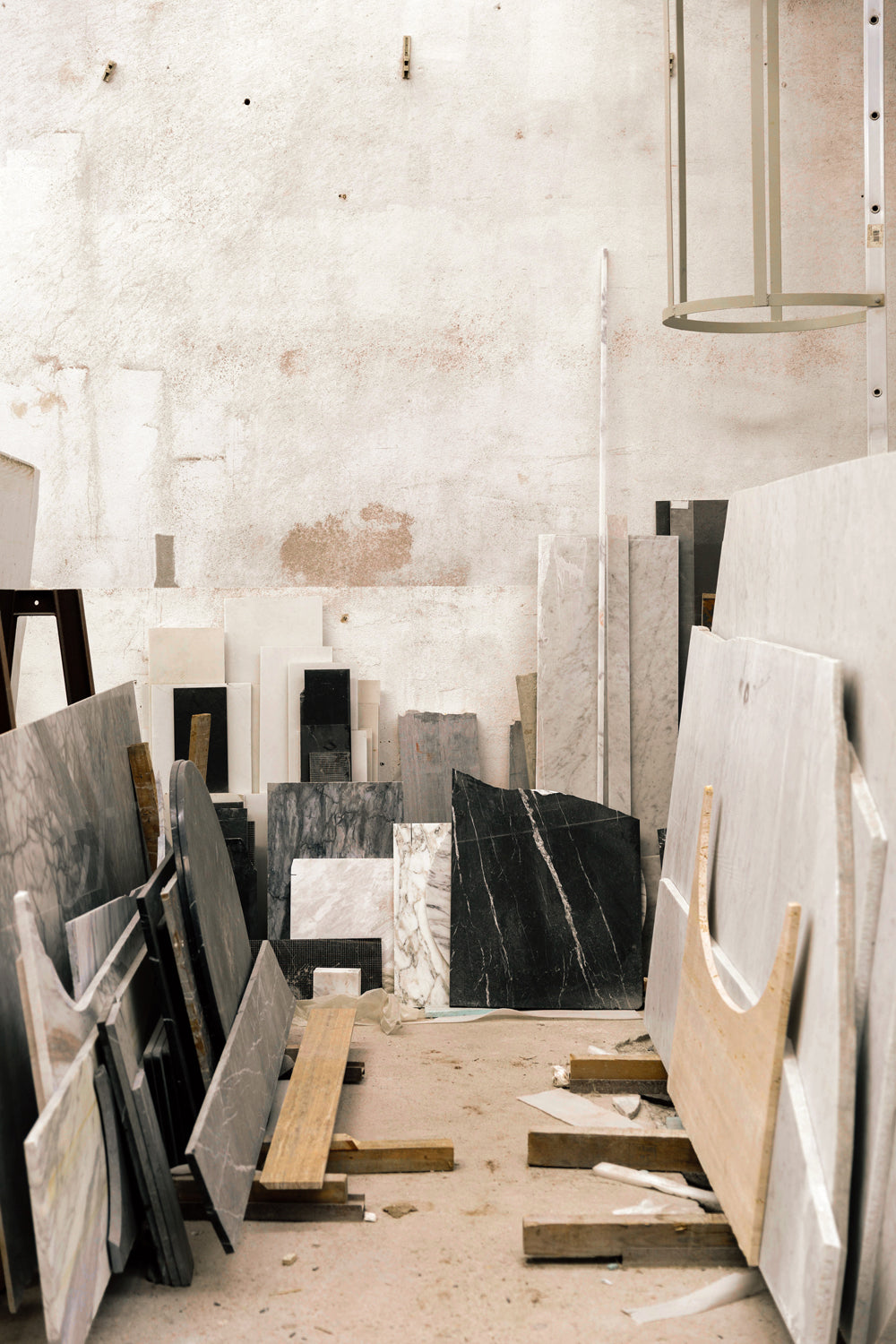 Workshop corner with stacked marble and stone slabs in white, grey and