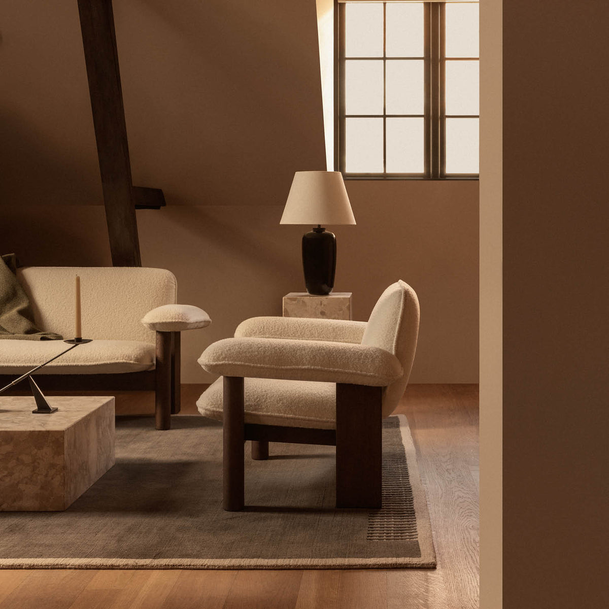 Cream boucle armchair and sofa with dark wooden legs, marble coffee table