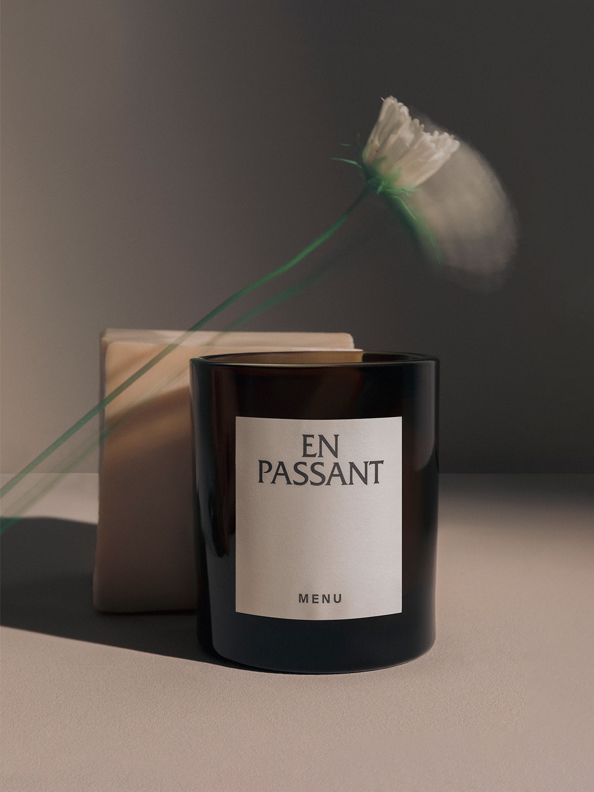 The MENU Olfacte Scented Candle, En Passant, in a dark glass jar,