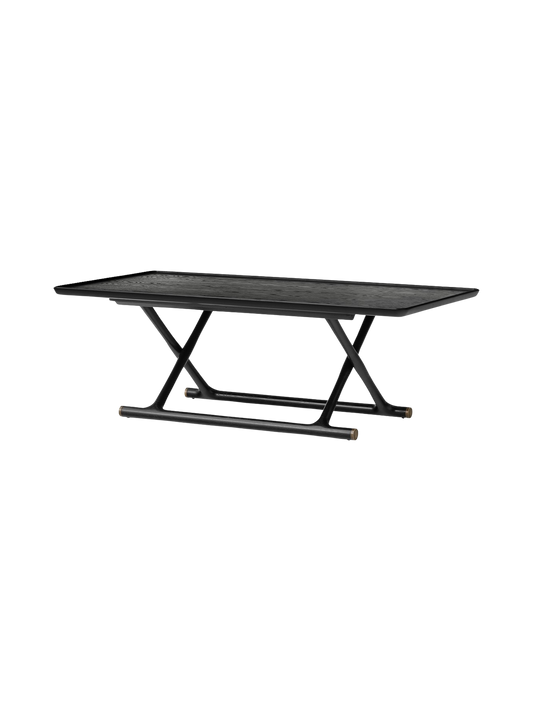 The Jäger Lounge Table in black stained oak shown at an angle, with a rectangular top and foldable X-frame base.