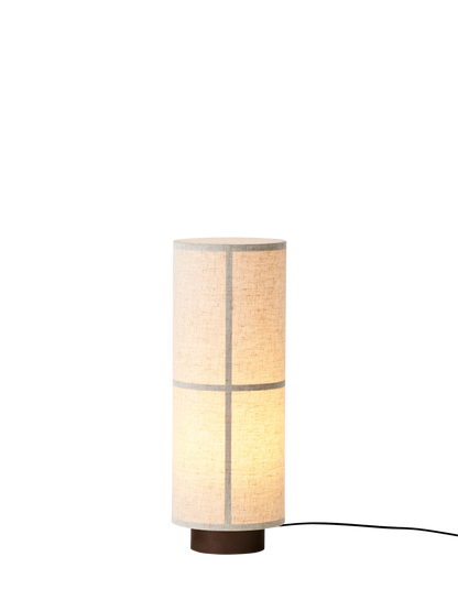 Hashira Table Lamp in raw linen, showcasing a cylindrical translucent shade with a wooden ash base and glowing warm light.