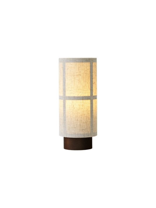 Hashira Table Lamp, Portable in raw linen with warm glowing light, shown from an angle against a black background.