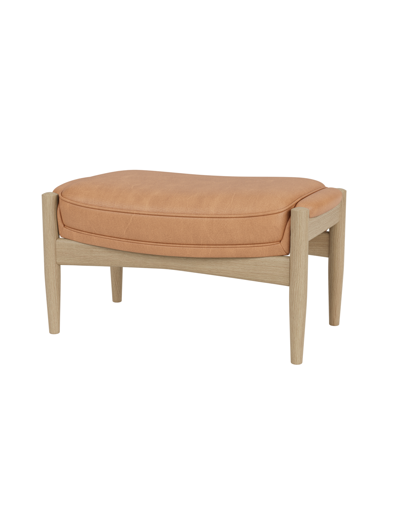 The Seal Ottoman featuring a tan Dunes leather cushion and a natural oak wood frame with sculpted mid-century legs.