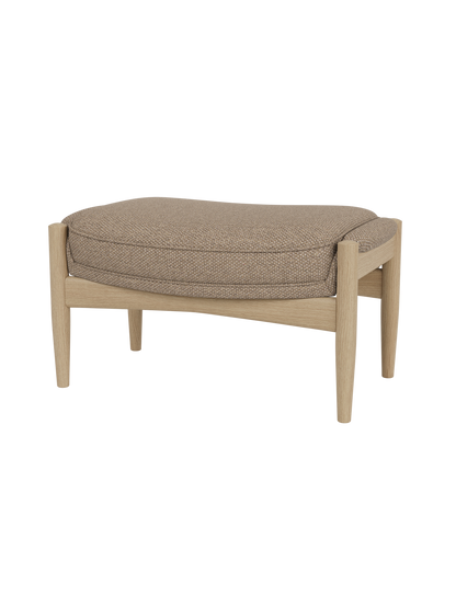 The Seal Ottoman featuring a natural oak frame and textured Logan Flint upholstery in a mid-century modern style.