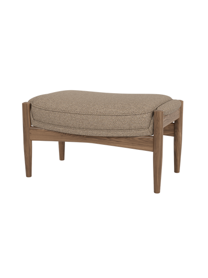 The Seal Ottoman in walnut wood with Logan Flint fabric upholstery, featuring an organic mid-century design.