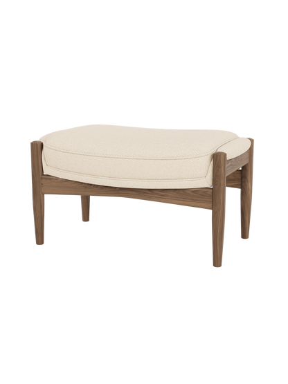 The Seal Ottoman featuring textured Logan Jasmine upholstery and a solid walnut frame with tapered, organic legs.