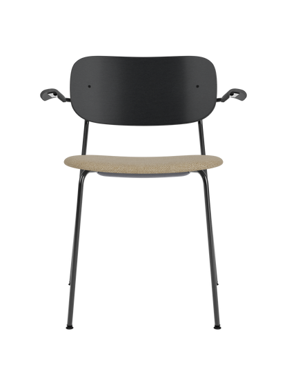 Co Dining Chair with armrests, a black oak backrest and a sand bouclé upholstered seat on a black metal frame.