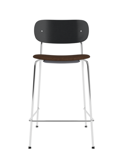 Co Counter Chair with a black painted oak back, bouclé upholstery seat, and chrome frame against a black background.