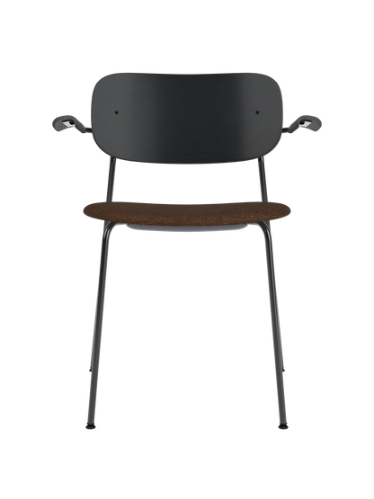 Co Dining Chair with armrests, black frame, black painted oak backrest, and a textured brown bouclé upholstered seat.