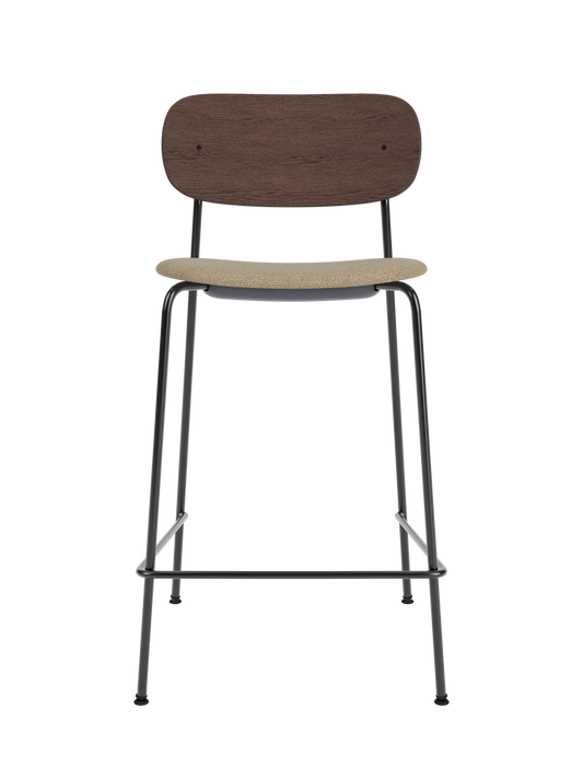 Co Counter Chair in dark stained oak and black steel with an upholstered seat in bouclé fabric against a black background.