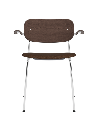 Co Dining Chair with armrests, featuring a chrome frame, dark stained oak backrest and brown bouclé upholstered seat.
