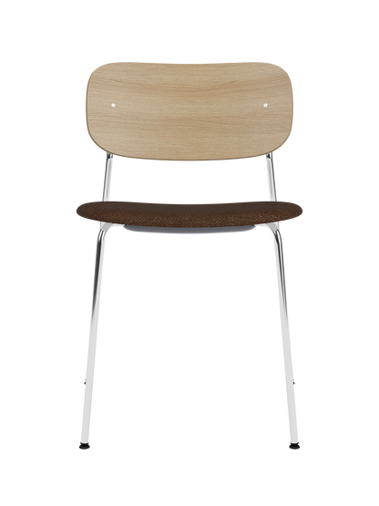 Co Dining Chair featuring a natural oak back, slim chrome frame and a dark bouclé upholstered seat.