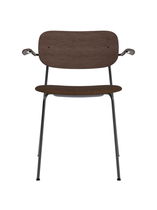 Co Dining Chair with armrests, featuring a dark stained oak back and brown bouclé upholstered seat on a black steel frame.