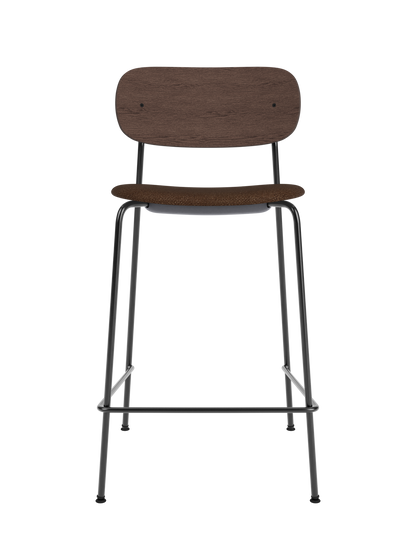 Co Counter Chair with dark stained oak back and brown bouclé upholstered seat on a slender black metal frame.