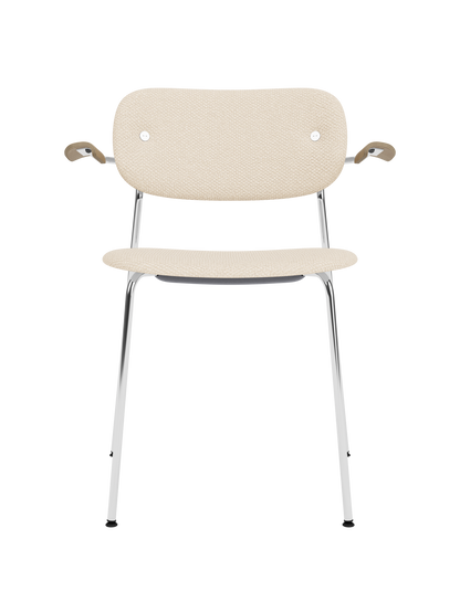 Fully upholstered Co Dining Chair in Logan Jasmine fabric with natural oak armrests and a polished chrome frame.