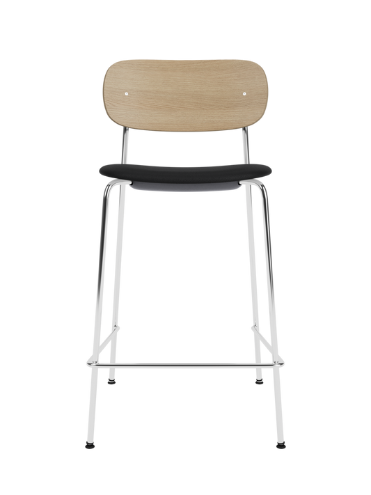 Co Counter Chair in natural oak with a black upholstered seat and chrome steel frame against a black background.