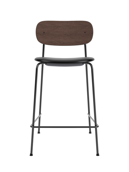 Co Counter Chair with a dark stained oak back and black upholstered seat on a slender black steel frame with footrest.