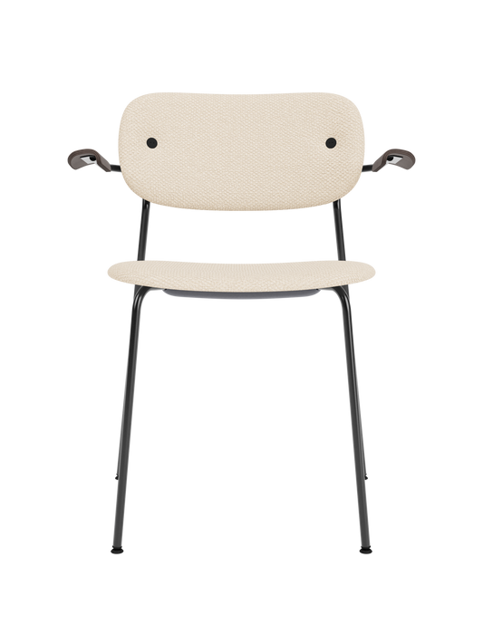 Co Dining Chair with armrests featuring Logan Jasmine cream upholstery and dark stained oak on a black steel base.
