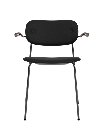 Black fully upholstered Co Dining Chair with dark stained oak armrests and a sleek powder-coated steel frame.