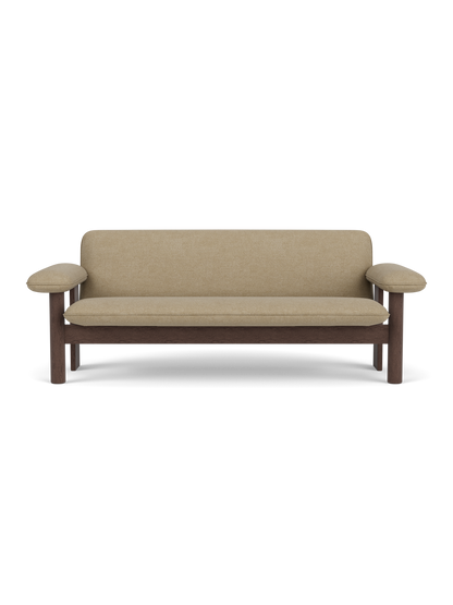 A front view of the Brasilia Sofa, featuring a dark stained oak frame with thick cushions upholstered in Audo Bouclé 02.