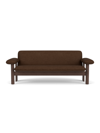 A front-on view of the Brasilia Sofa, featuring a dark stained oak frame and upholstered in a textured, brown bouclé fabric.