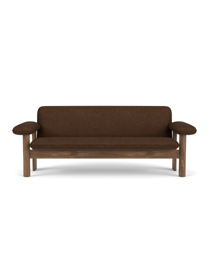 A front view of the Brasilia Sofa with a solid walnut frame and brown Audo Bouclé 07 upholstery against a black background.