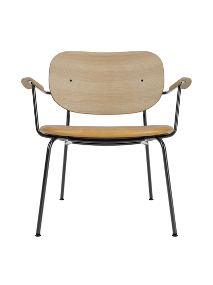 Co Lounge Chair in natural oak with a tan Dakar 0250 leather seat and a slender black powder-coated steel frame.