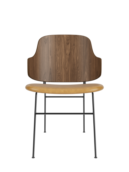 The Penguin Dining Chair featuring a curved walnut back and tan upholstered seat on a slender black metal frame.