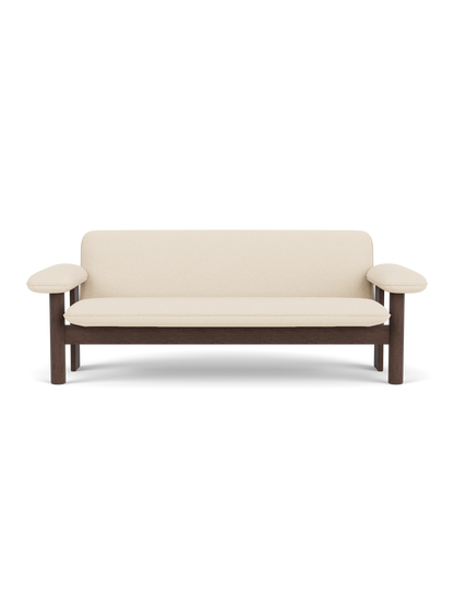 Front view of the Brasilia Sofa, featuring a dark stained oak frame and upholstered in light-coloured Logan Jasmine textile.