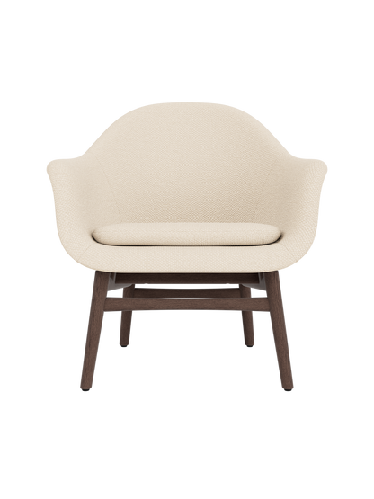Harbour Lounge Chair in light Logan Jasmine fabric with a curved shell and sculptural dark stained oak frame.
