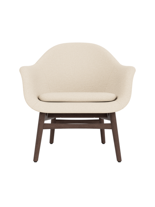 Harbour Lounge Chair in light Logan Jasmine fabric with a curved shell and sculptural dark stained oak frame.