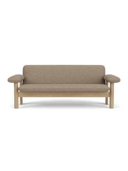 Front view of the Brasilia Sofa. The two-seater has a natural oak frame with rounded legs and exaggerated, padded armrests.