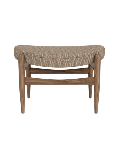 Elizabeth Ottoman in Logan Flint textured fabric and walnut wood, featuring a curved, comfortable seat.