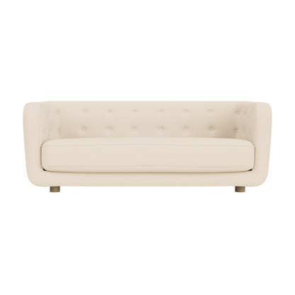 Vilhelm Sofa in Logan Jasmine fabric with natural oak legs, featuring a buttoned back and curved three-seater design.
