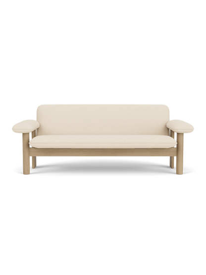 A front-on view of the Brasilia Sofa, featuring a natural oak frame with rounded armrests and plush Logan Jasmine upholstery.