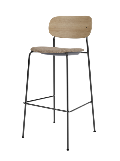 Co Bar Chair with a black steel frame, natural oak veneer backrest and textured beige Logan Flint upholstered seat.
