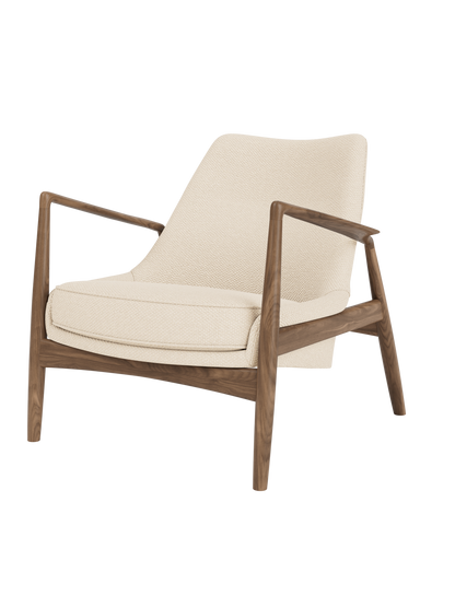 The Seal Lounge Chair, Low Back in walnut with textured Logan Jasmine cream fabric and signature angled wooden arms.