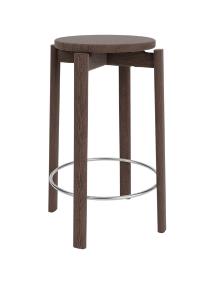 Round dark-walnut wooden bar stool with four vertical legs and a chrome circular footrest, viewed close-up on black