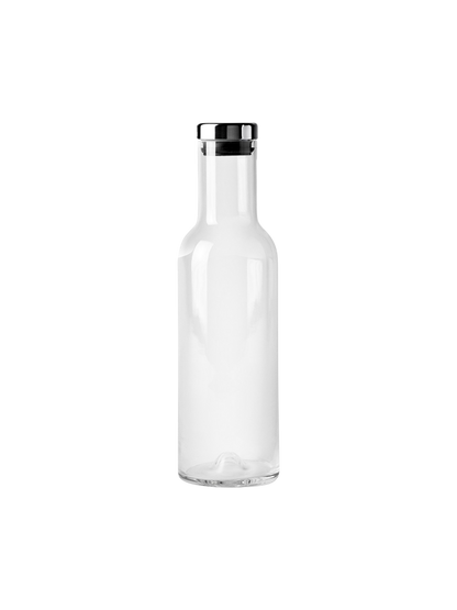 A front-view, studio shot of the Audo Bottle Carafe with Steel Lid. The minimalist carafe is made of clear glass.