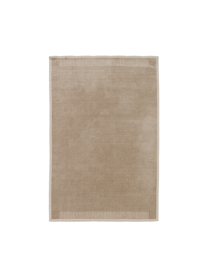 A top-down view of the rectangular Duomo Rug in Limestone Beige, showing a solid-coloured body and decorative ribbed borders.